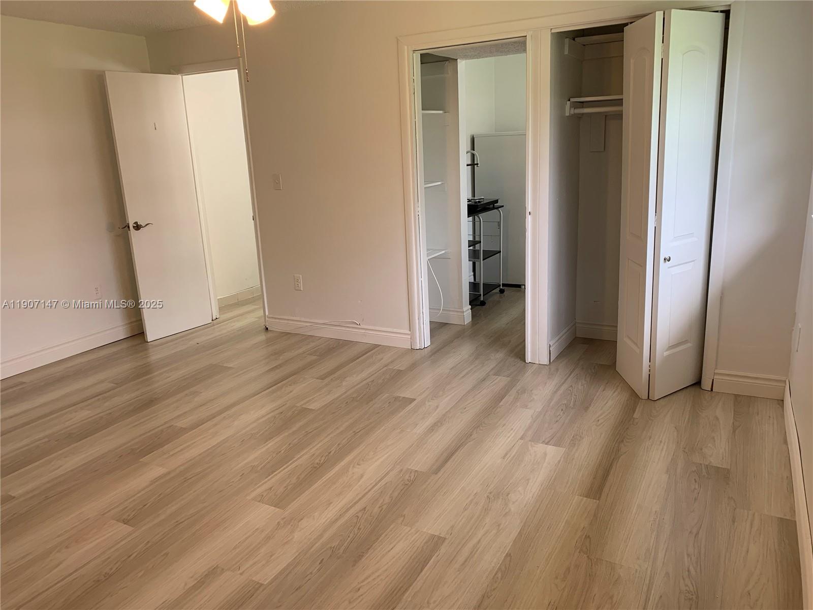 10040 Southwest 198th Street Cutler Bay, FL 33157 - Photo 4 of 17 an empty room with wooden floor and closet