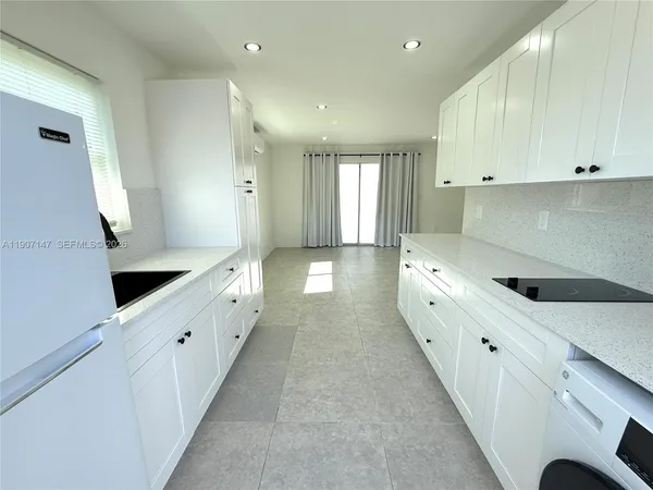 a large white kitchen with double vanity sink and a window