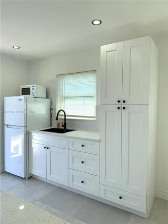 a view of cabinets a sink and a window in a room