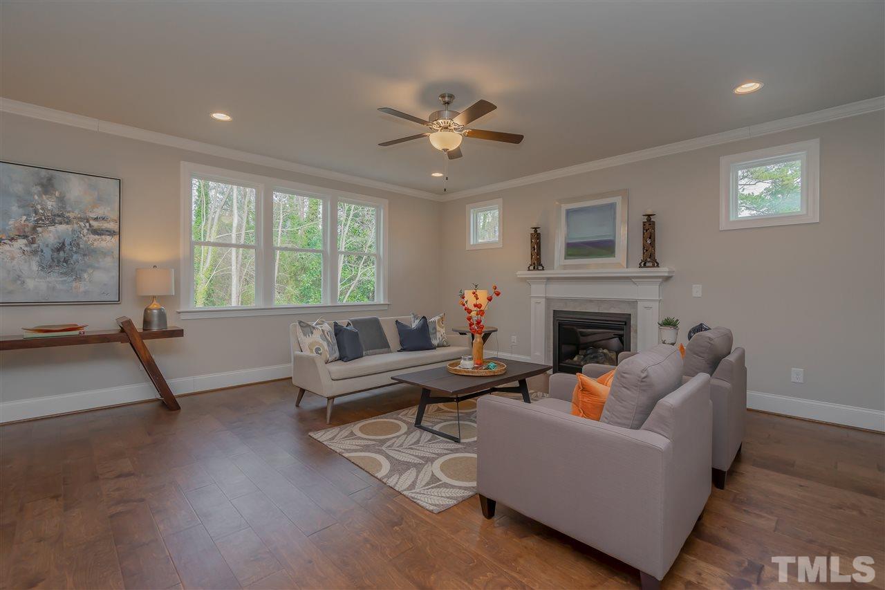 3911 Sue Lane Raleigh, NC 27604 - Photo 12 of 25 a living room with furniture a fireplace and a flat screen tv