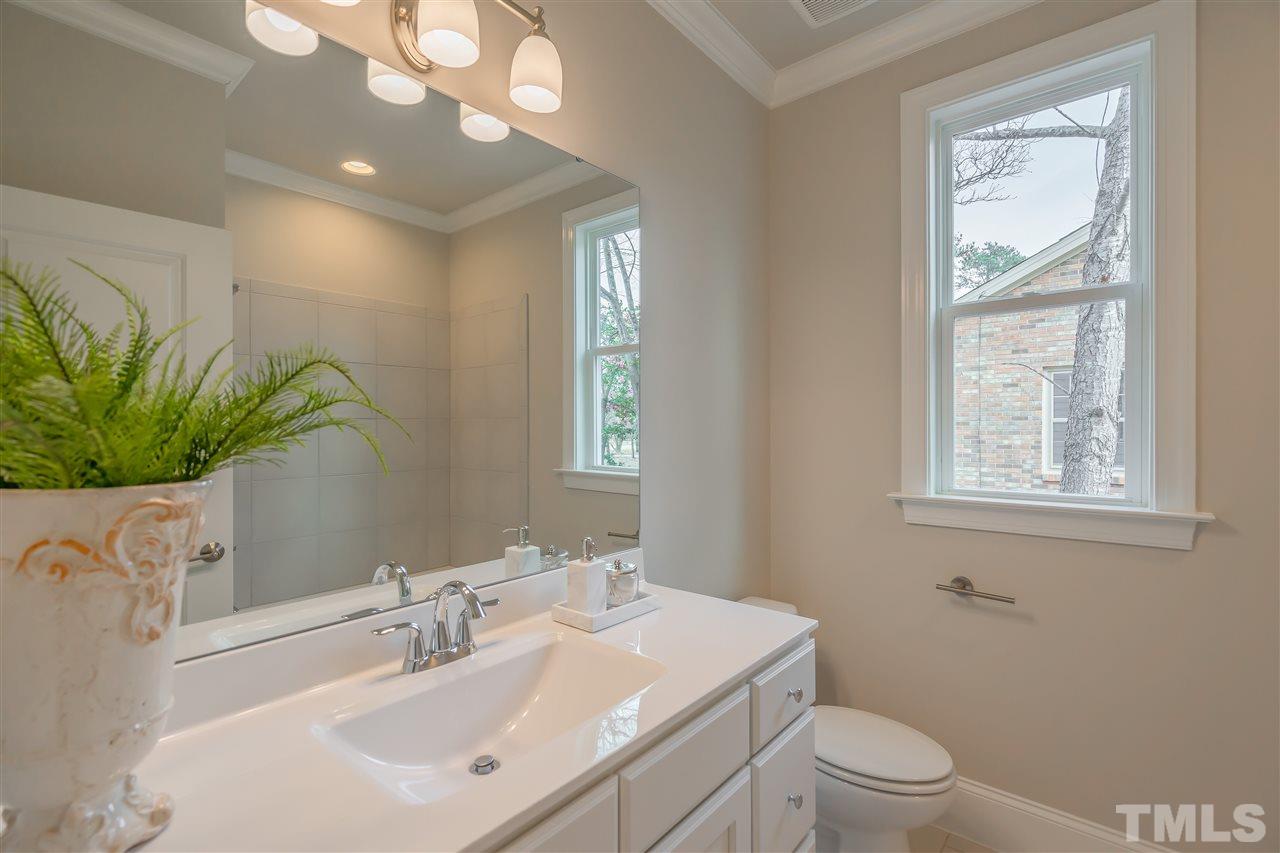 3911 Sue Lane Raleigh, NC 27604 - Photo 15 of 25 a bathroom with a sink a mirror and a toilet