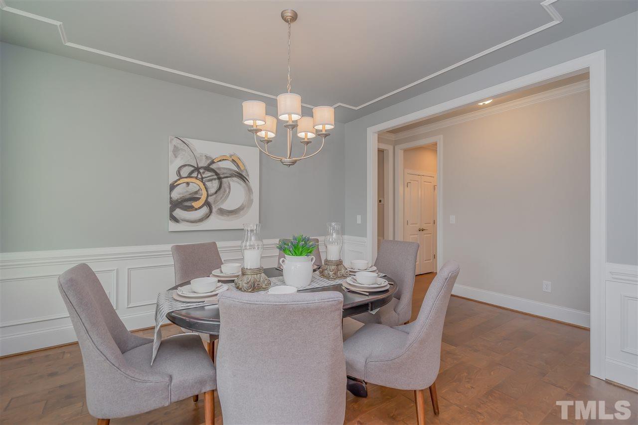 3911 Sue Lane Raleigh, NC 27604 - Photo 3 of 25 a view of a dining room with furniture a chandelier and wooden floor