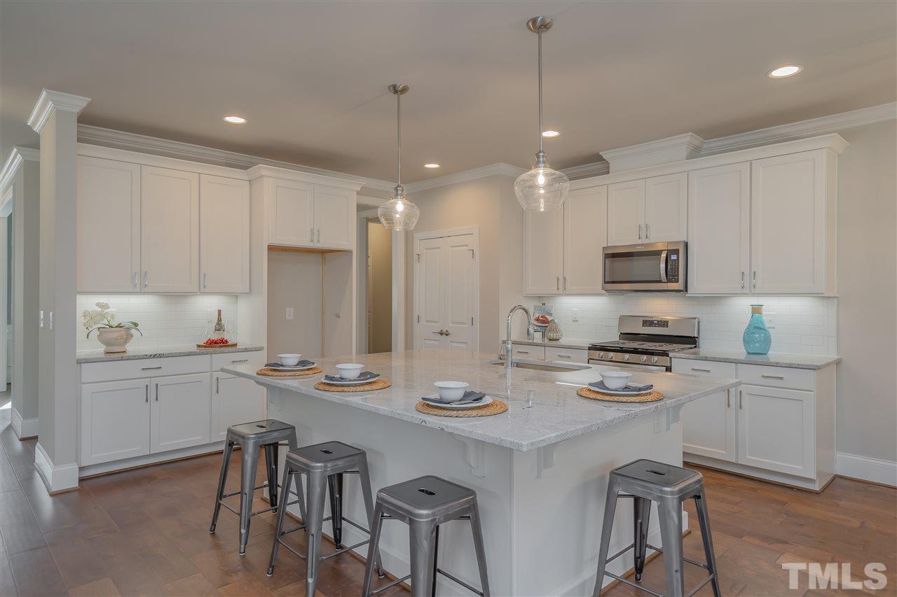 3911 Sue Lane Raleigh, NC 27604 - Photo 5 of 25 a kitchen with stainless steel appliances granite countertop a stove top oven a refrigerator a sink and white cabinets