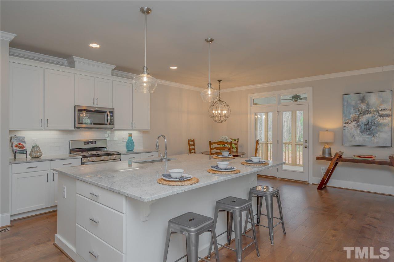 3911 Sue Lane Raleigh, NC 27604 - Photo 9 of 25 a kitchen with a sink a stove a dining table and chairs