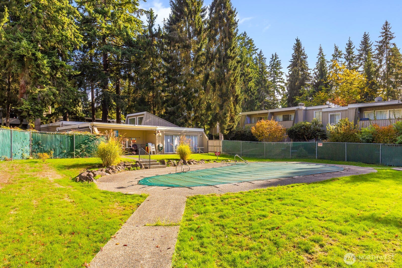 4823 180th Street Southwest, Unit H203 Lynnwood, WA 98037 - Photo 22 of 26 a view of a swimming pool with lawn chairs and plants