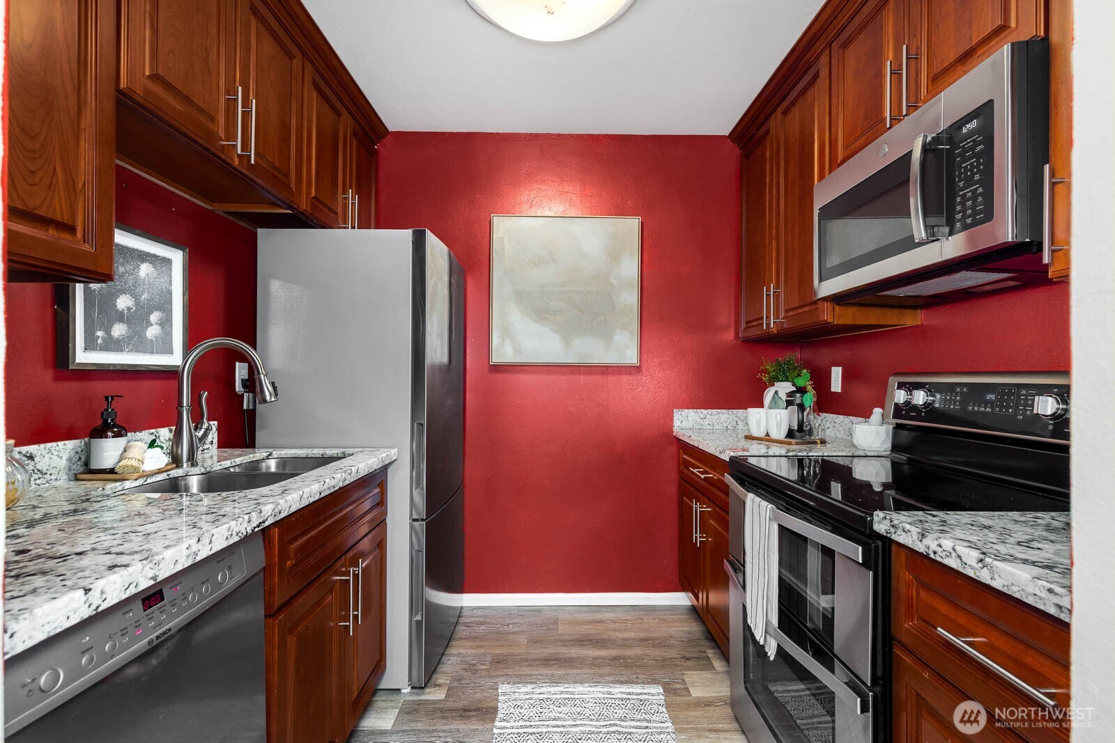 4823 180th Street Southwest, Unit H203 Lynnwood, WA 98037 - Photo 3 of 26 a kitchen with stainless steel appliances granite countertop a stove a sink and a microwave