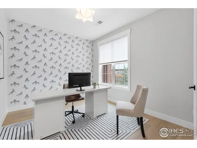 a view of a workspace with furniture and a window