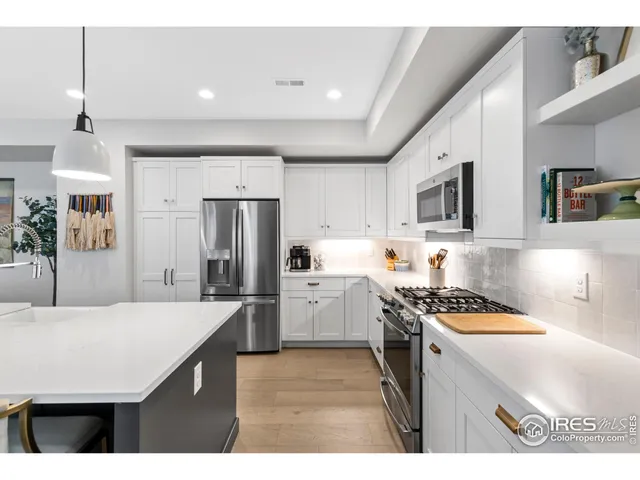 a kitchen that has a lot of cabinets a sink and appliances