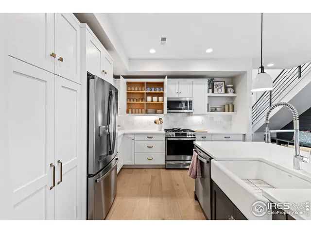 a kitchen with stainless steel appliances kitchen island wooden cabinets a stove a sink and a refrigerator