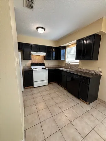 a view of empty room with window and chandelier
