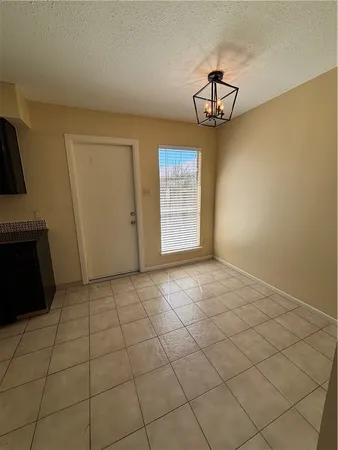 a kitchen with granite countertop a refrigerator and a stove top oven