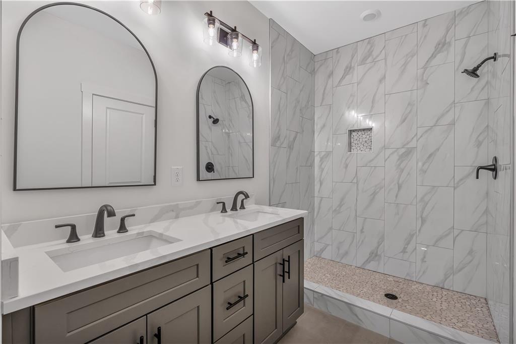 44 Puckett Road Emerson, GA 30137 - Photo 19 of 39 a bathroom with a granite countertop sink a mirror and shower