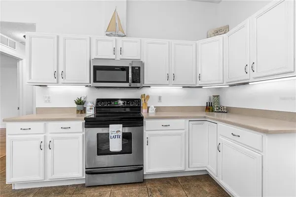 a kitchen with white cabinets and stainless steel appliances
