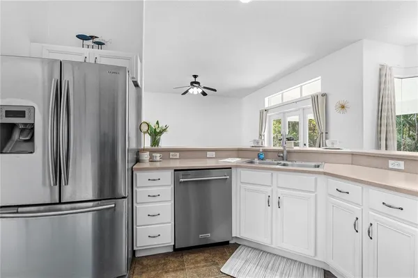 a kitchen with white cabinets and refrigerator