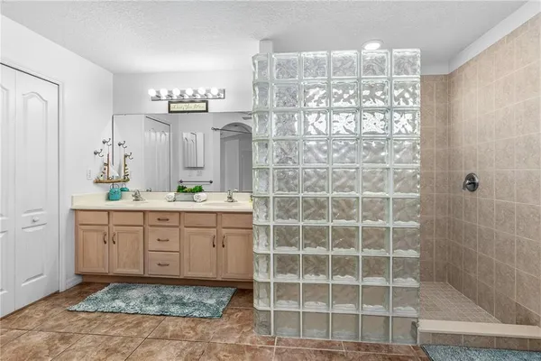 a bathroom with a granite countertop sink a mirror and a shower