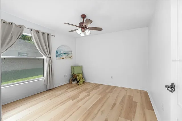 a view of room with a window and a ceiling fan