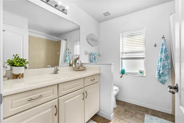 a bathroom with a sink a toilet and a window