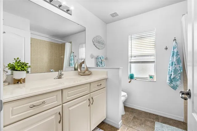 a bathroom with a sink a toilet and a window