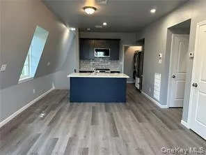 a view of kitchen with stainless steel appliances granite countertop cabinets and wooden floor