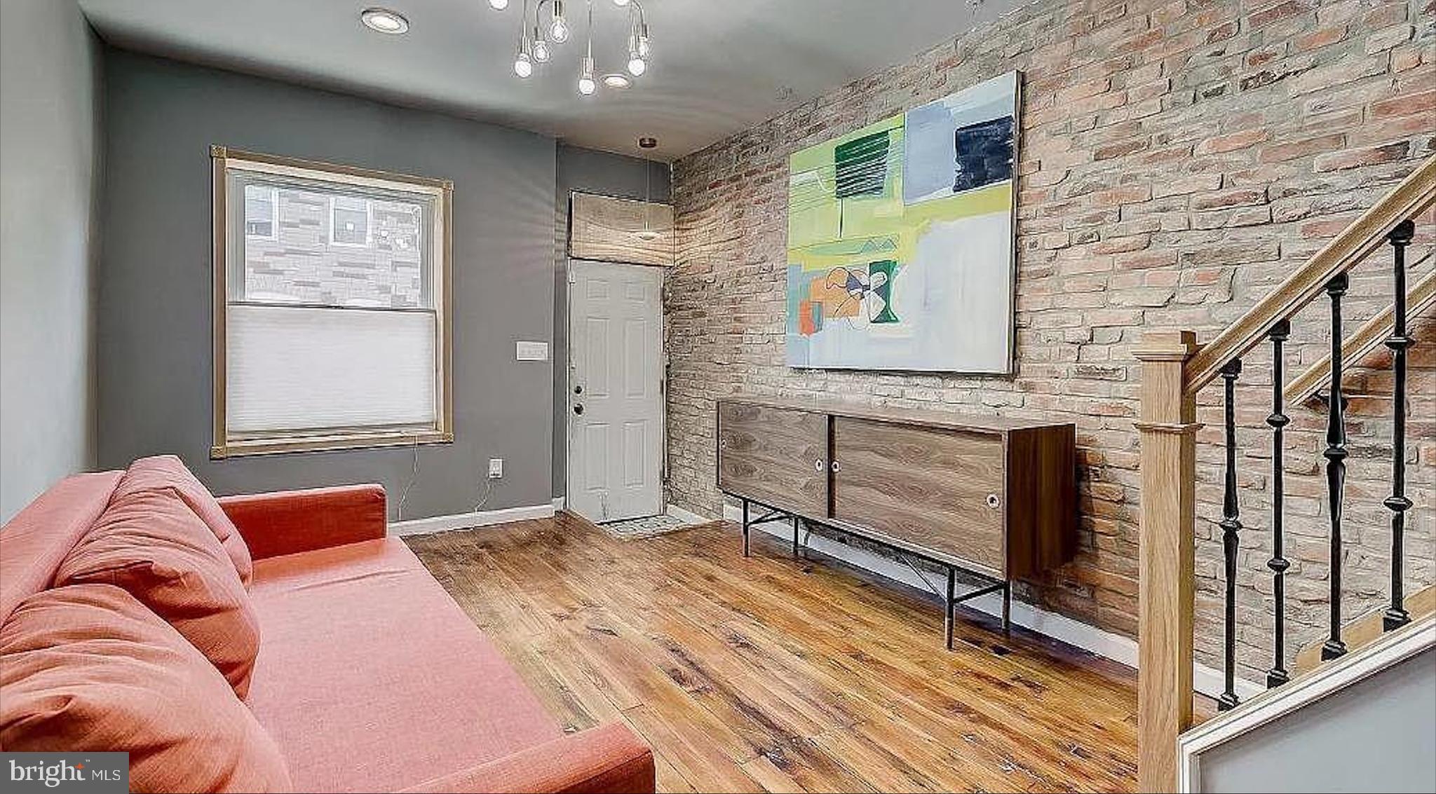 150 North Curley Street Baltimore, MD 21224 - Photo 2 of 10 a bedroom with a bed and wooden floor