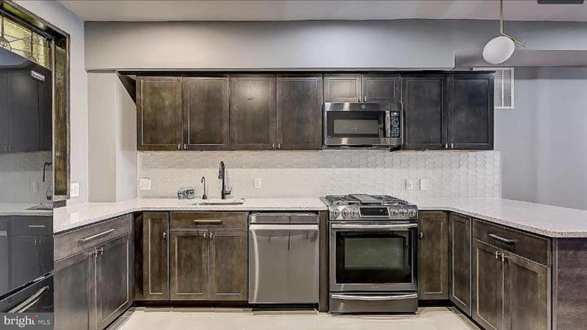 150 North Curley Street Baltimore, MD 21224 - Photo 5 of 10 a kitchen with stainless steel appliances a stove a sink and a microwave