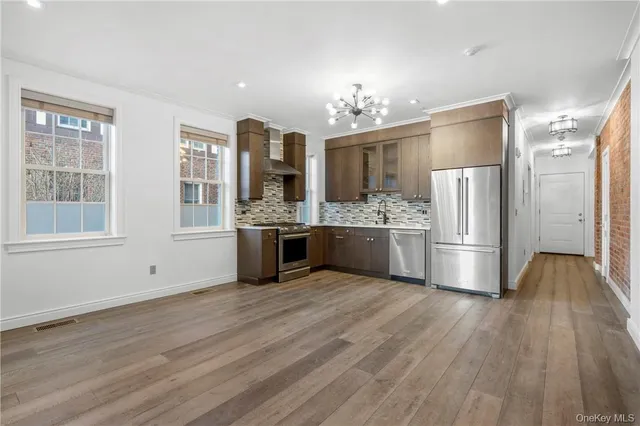 a kitchen with stainless steel appliances a refrigerator and wooden floor