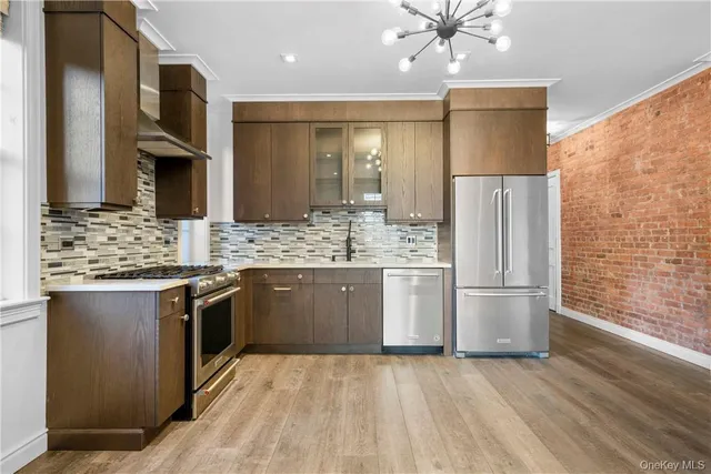 a kitchen with stainless steel appliances kitchen island granite countertop a refrigerator and a sink