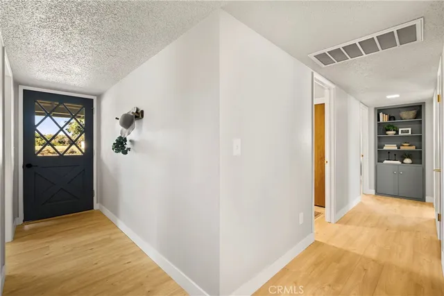 a view of hallway with livingroom and wooden floor