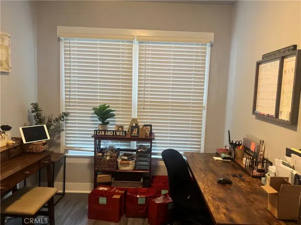 a view of a workspace with furniture and a window