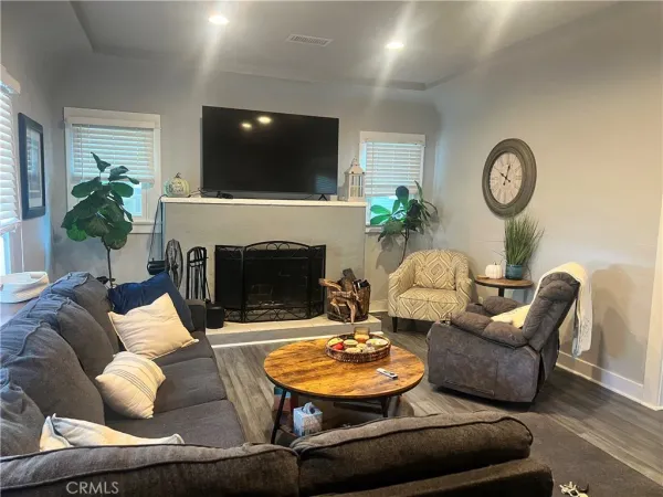 a living room with furniture a fireplace and a flat screen tv