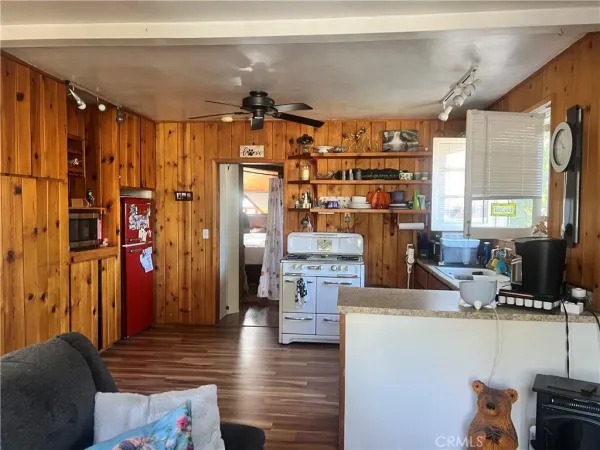 a kitchen with stainless steel appliances kitchen island granite countertop a refrigerator and a wooden cabinets