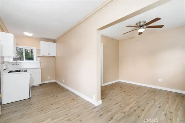 a view of a kitchen with wooden floor and a ceiling fan