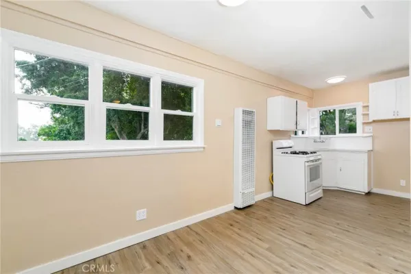a kitchen with granite countertop white cabinets and white appliances