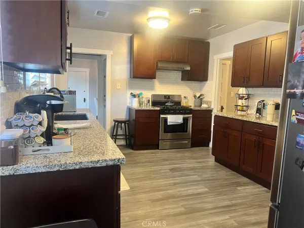 a kitchen with stainless steel appliances granite countertop a sink stove and refrigerator
