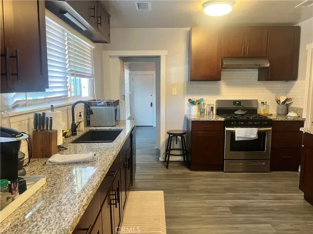 a kitchen with stainless steel appliances granite countertop a sink stove and refrigerator