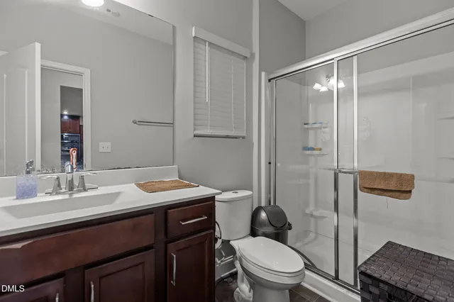 a bathroom with a sink toilet vanity and shower
