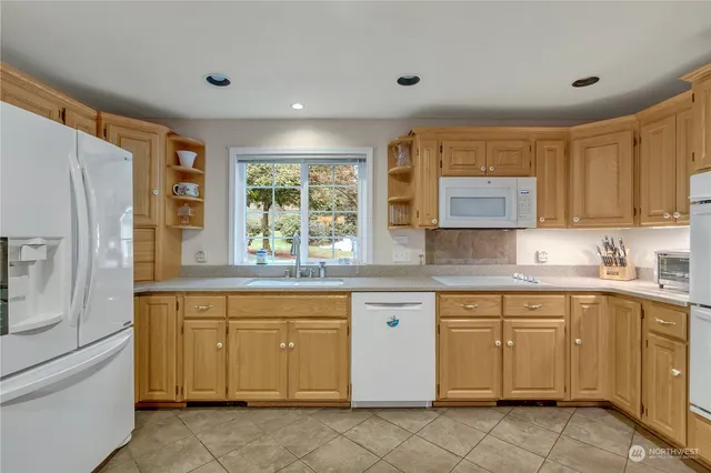 a kitchen with a sink window and refrigerator
