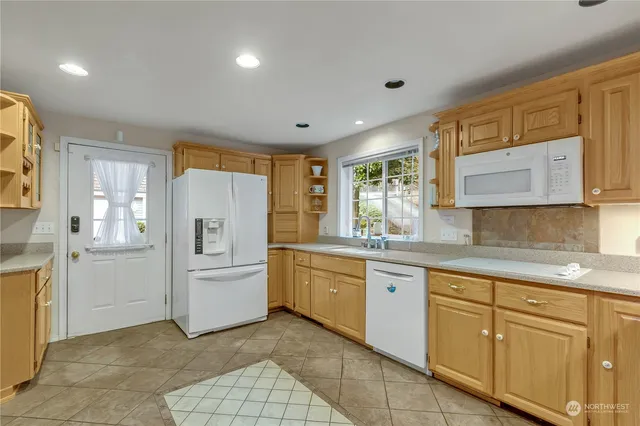 a kitchen with white cabinets and white appliances