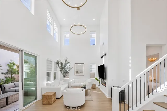 a living room with furniture a flat screen tv and floor to ceiling window