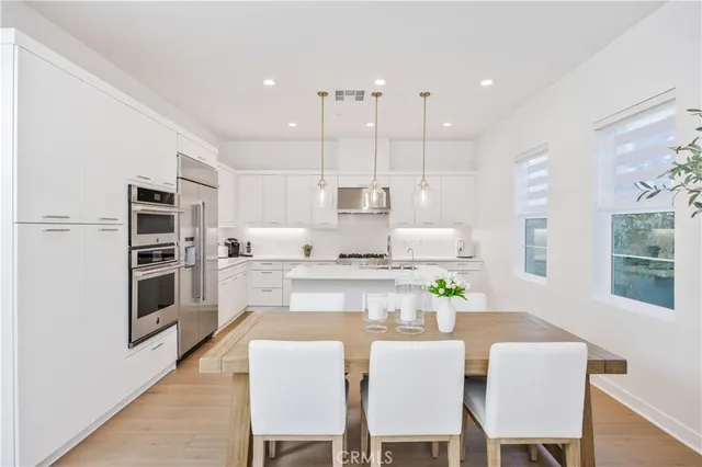 a large kitchen with a table and chairs