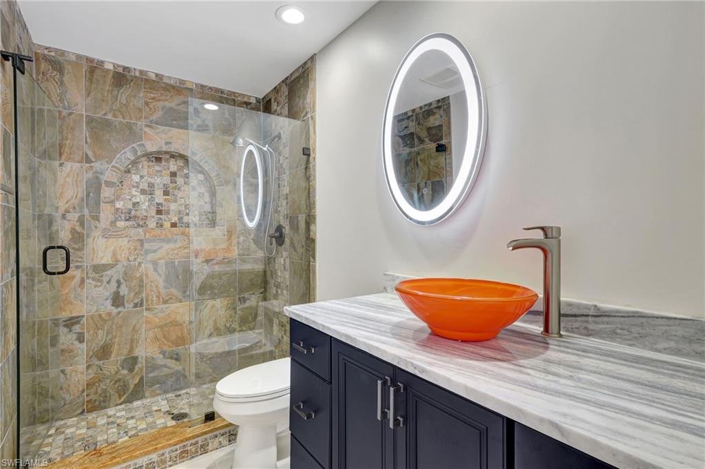 112 Capri Boulevard Naples, FL 34113 - Photo 23 of 39 a bathroom with a granite countertop sink a toilet and a shower