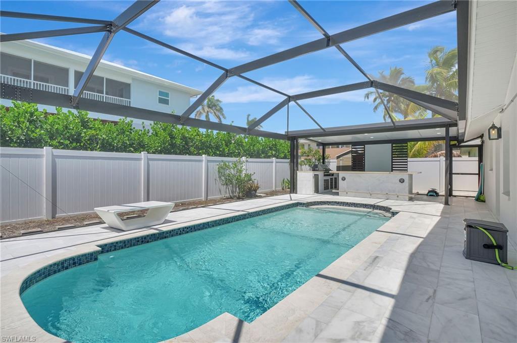 112 Capri Boulevard Naples, FL 34113 - Photo 31 of 39 a backyard of a house with a garden and barbeque oven