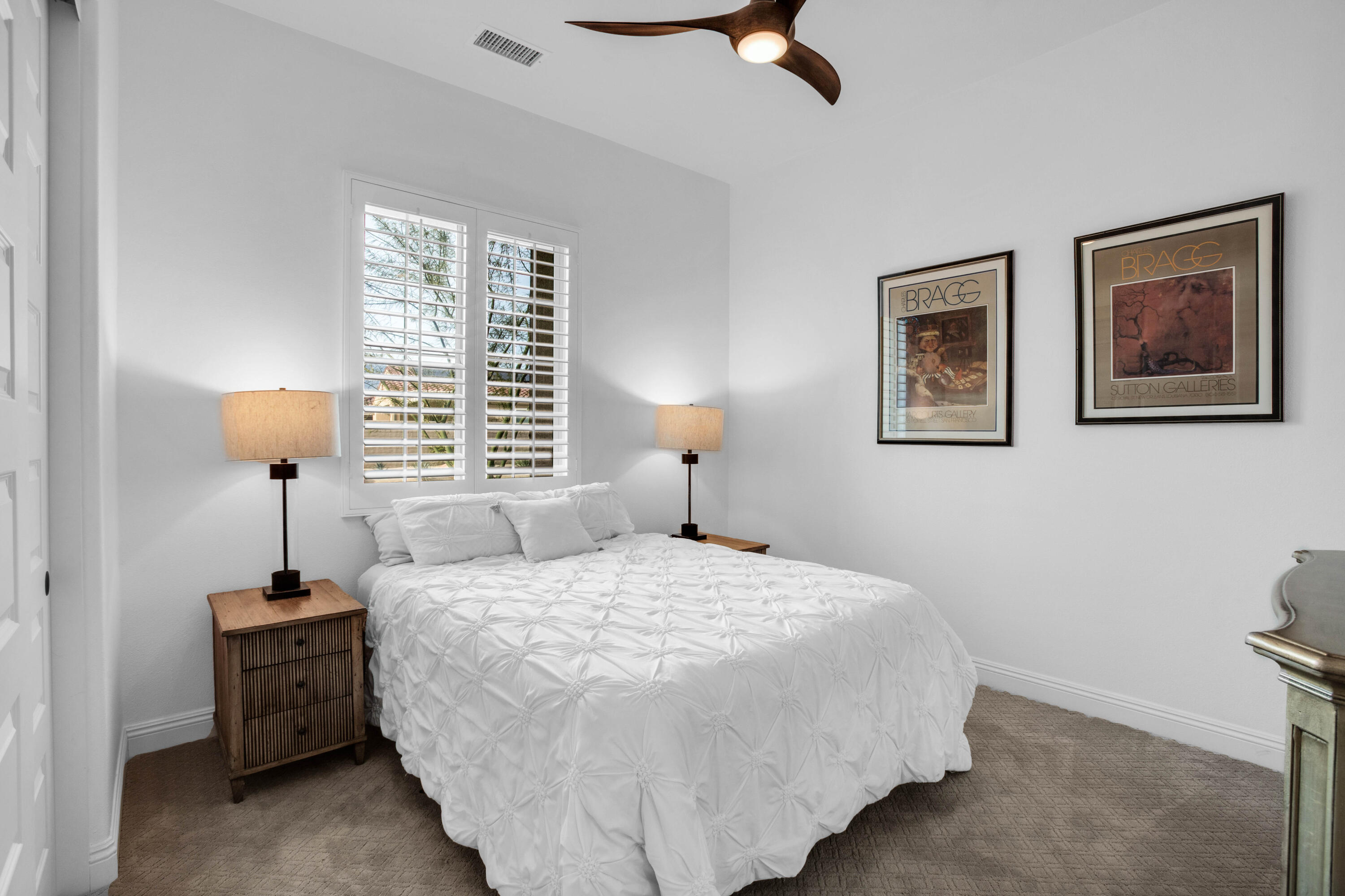 32 Cork Tree Rancho Mirage, CA 92270 - Photo 26 of 58 a bedroom with a bed and a chandelier