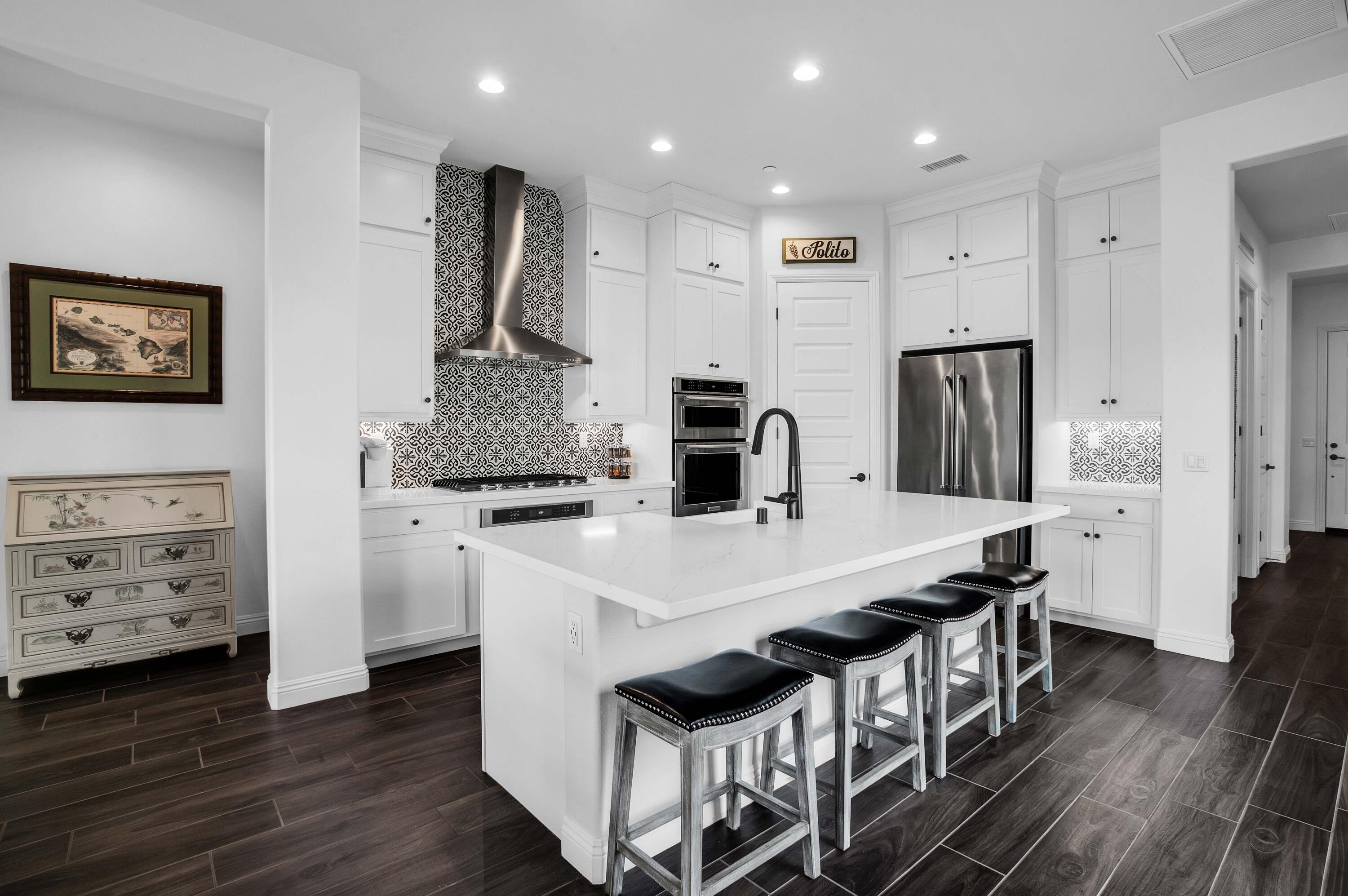 32 Cork Tree Rancho Mirage, CA 92270 - Photo 3 of 58 a kitchen with stainless steel appliances kitchen island a table chairs and refrigerator