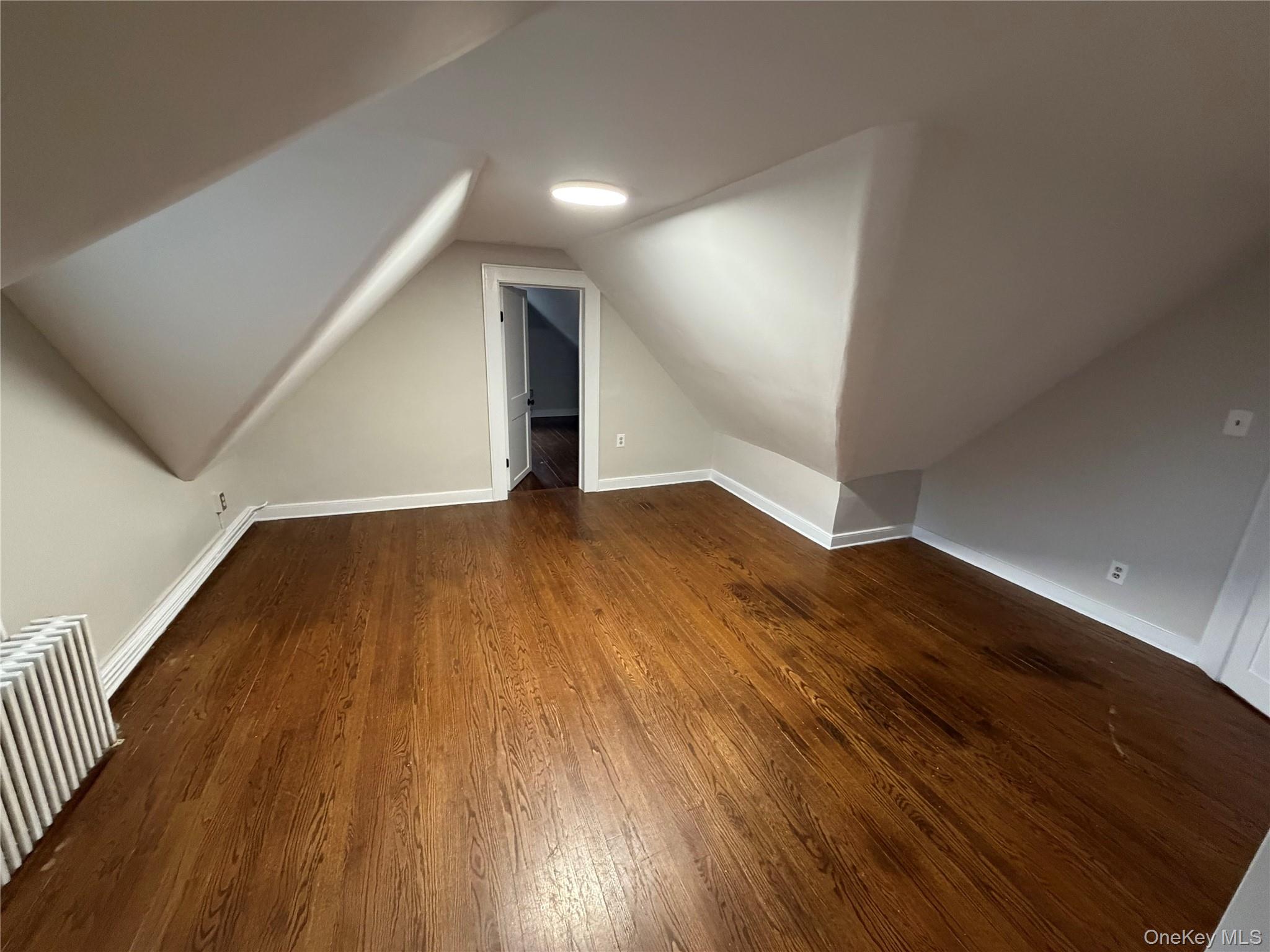 196 Depew Avenue, Unit 3 Nyack, NY 10960 - Photo 5 of 15 dark wood finished floors, vaulted ceiling, and radiator