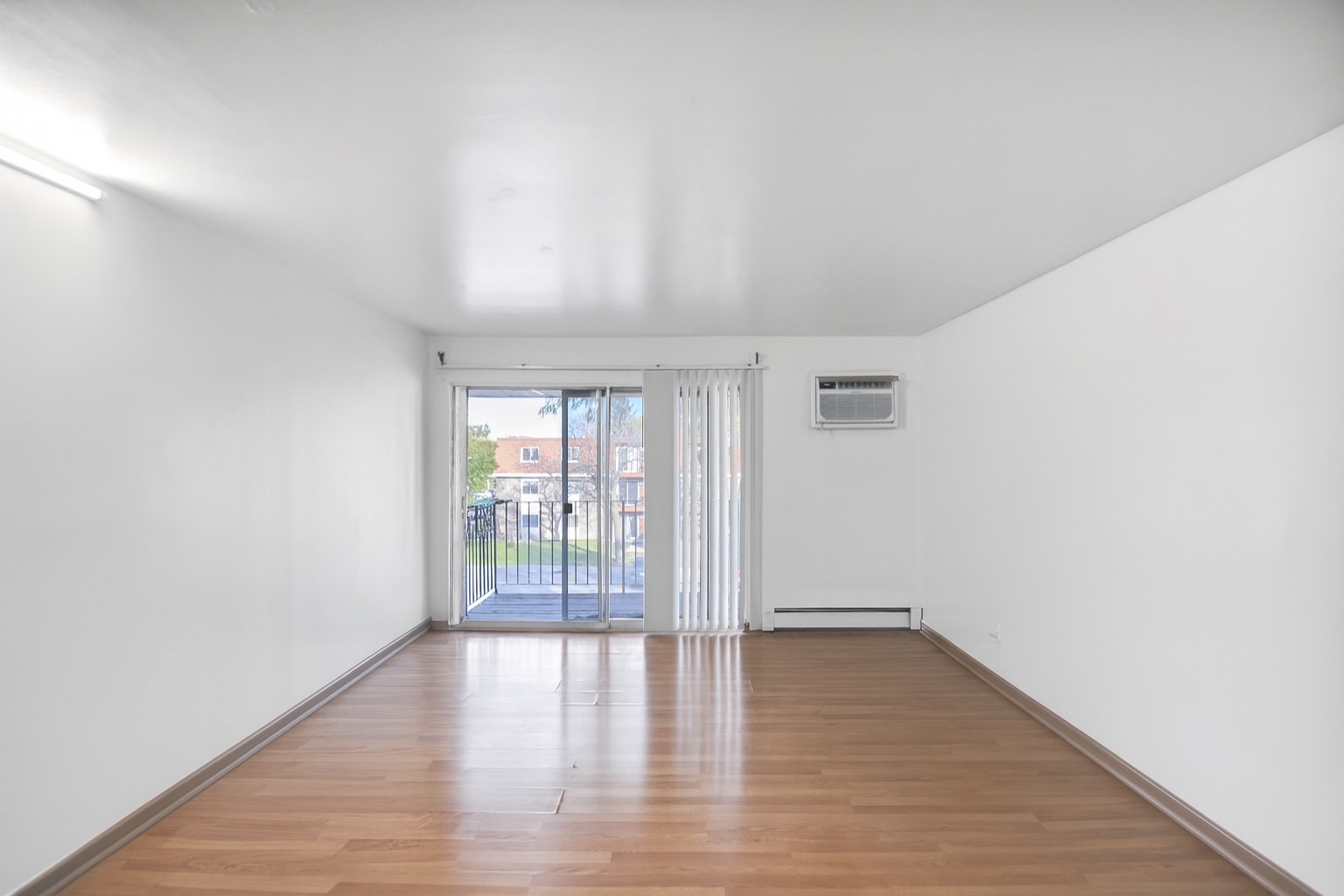 1080 Knoll Lane, Unit 305 Hoffman Estates, IL 60169 - Photo 4 of 10 a view of an empty room with wooden floor and a window