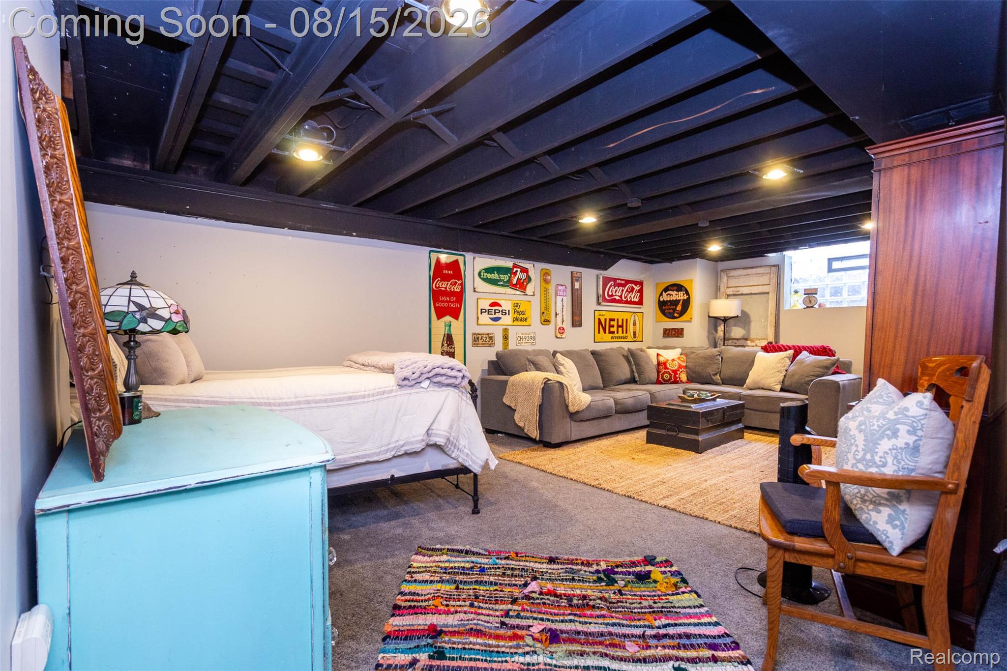 29604 Chelmsford Road Southfield, MI 48076 - Photo 27 of 39 Recessed ceiling lights, exposed dark-painted ceiling joists, light gray walls, window, and wood-finish built-in cabinetry