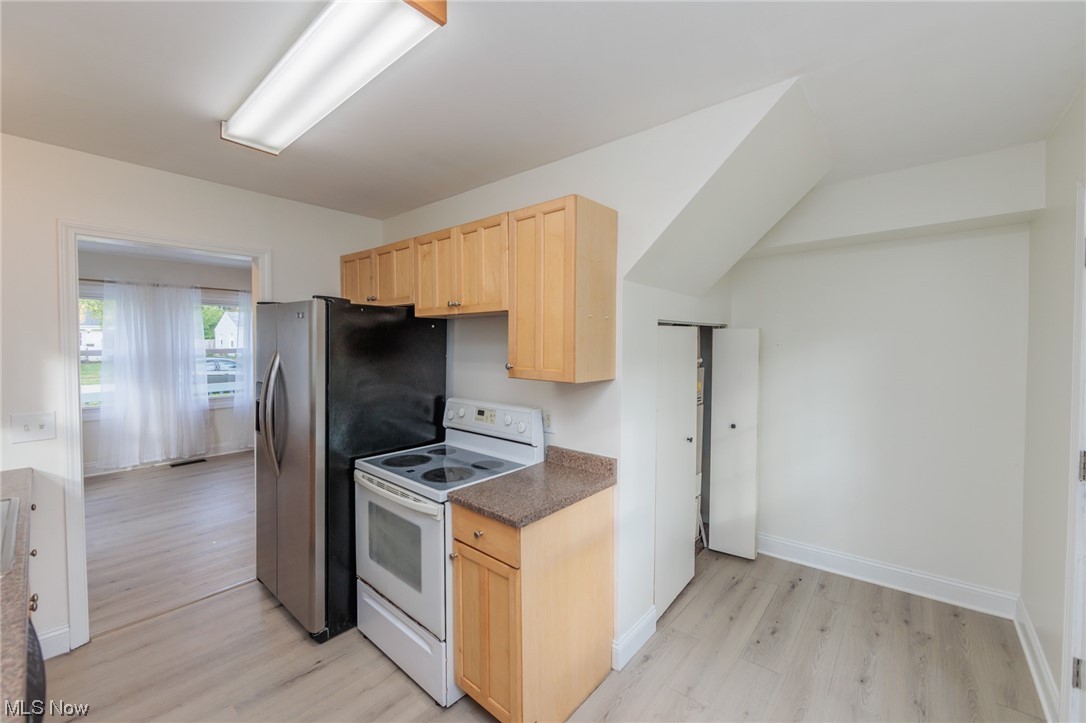 355 Dellwood Road Avon Lake, OH 44012 - Photo 12 of 35 Kitchen with light brown cabinetry, white electric range oven, stainless steel refrigerator, and light hardwood floors