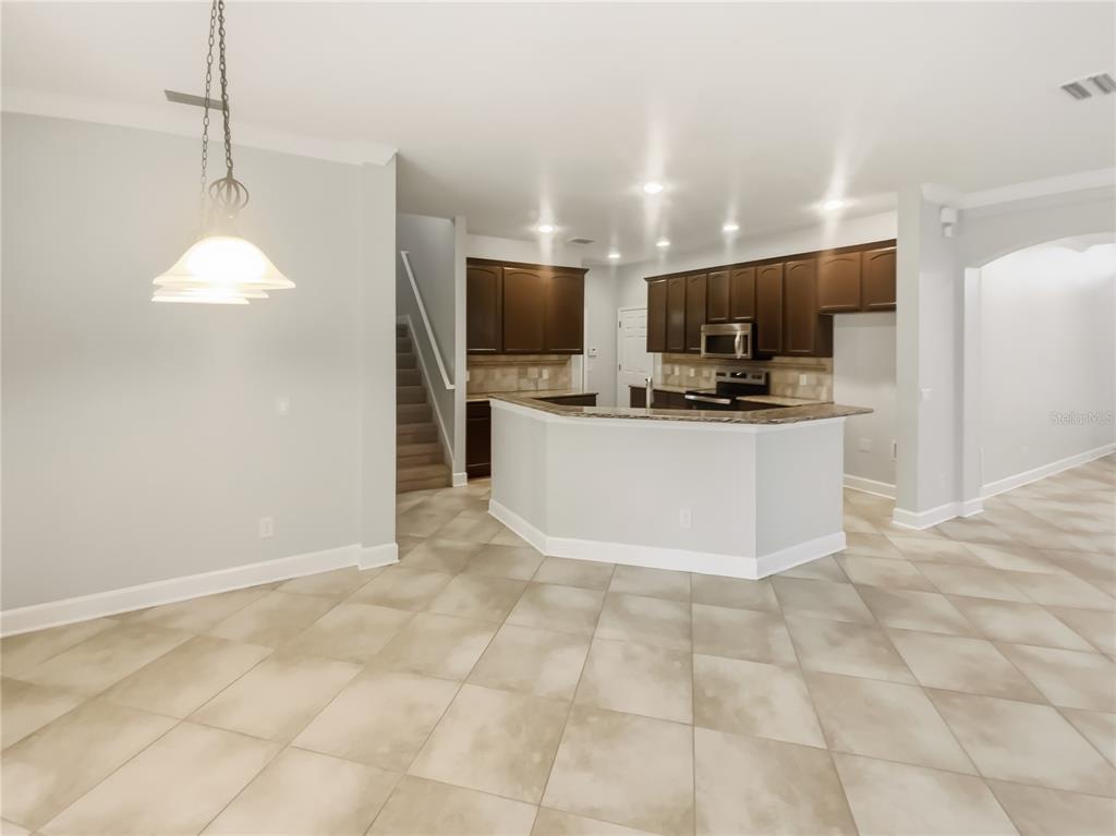 4307 Rustic Pine Place Wesley Chapel, FL 33544 - Photo 12 of 38 a kitchen with stainless steel appliances a stove a sink a microwave a refrigerator and a cabinets