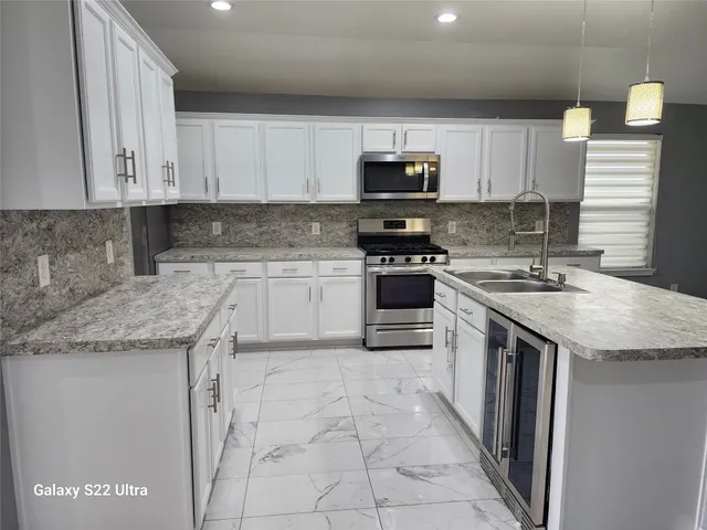 a kitchen with stainless steel appliances granite countertop a sink stove and cabinets